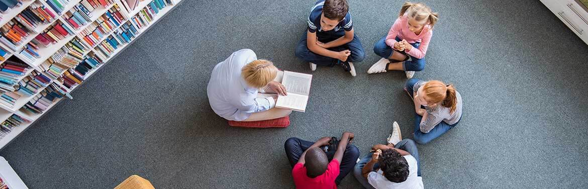 children sitting on floor in library for reading time
